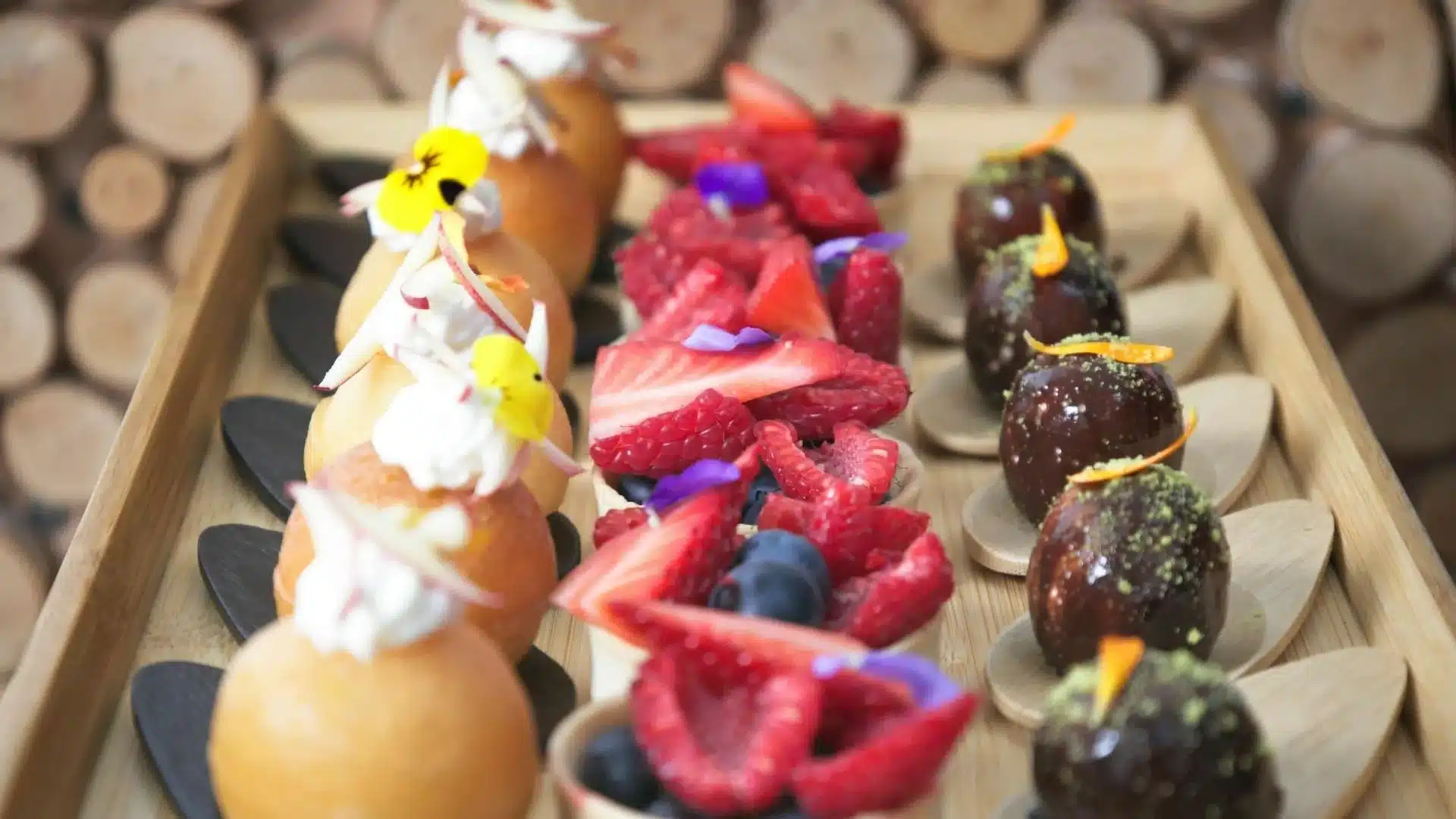 photo de dessert du traiteur terre vaudoise, boule chocolat et poudre pistache, tartelettes aux fruits rouges de saison, et baba au rhum